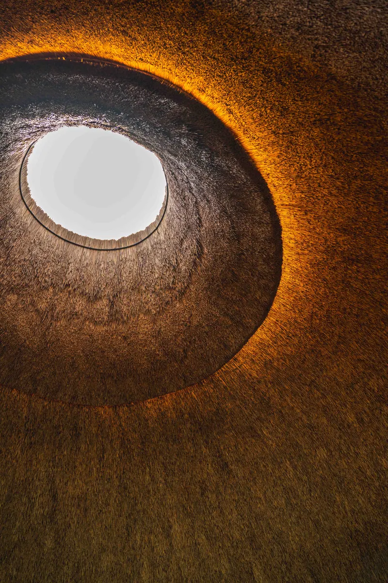 A circular skylight set into the thatch