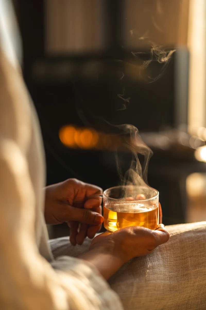 Steam rising from a cup of tea held in both hands